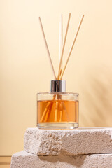 reed diffuser bottle on the podium. Incense sticks for the home with a floral scent with hard...