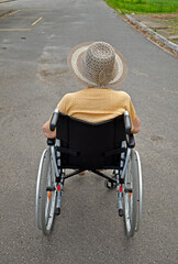 Old woman wheelchair user on the street