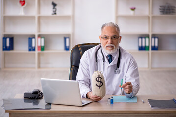 Old male doctor in remuneration concept