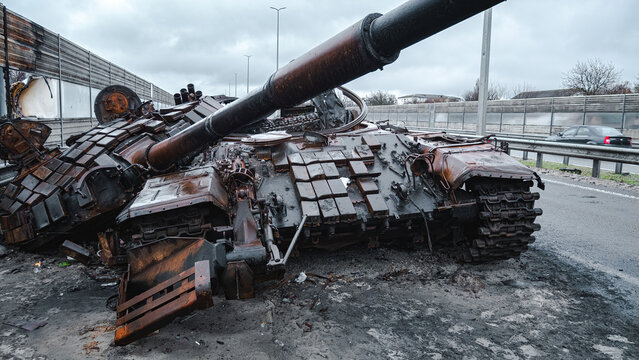 War in Ukraine, Zhytomyr highway, Kyiv region, a destroyed Russian tank with a torn off turret stands on the highway.