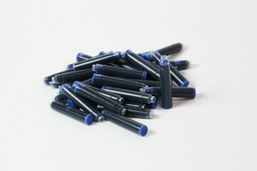 A heap of pen cartridges with blue ink, isolated on white background