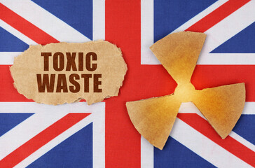 On the flag of Great Britain, the symbol of radioactivity and torn cardboard with the inscription - Toxic waste