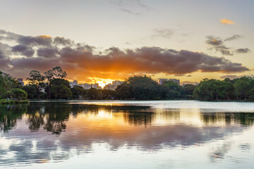 lindo por do Sol em parque da cidade de São Paulo. Reflexo do céu no lago. 