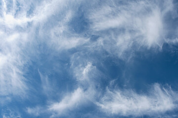 daytime blue sky with wind scattered white cirrus clouds as a natural backdrop