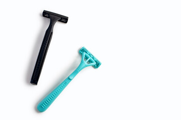 Two plastic razors in black and blue on a white background. Male and female disposable razor with free space for text. The concept of care for the appearance and care for the beauty of a person
