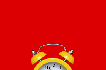 Yellow old-fashioned alarm clock with a dial on a red background with free space for text. The...