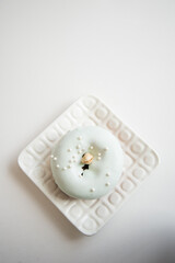 Obraz na płótnie Canvas A frosted pastel pistachio cake donut on a white plate