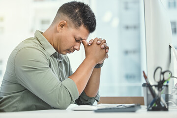 Im trying so hard to stay positive. Shot of a businessman looking stressed while sitting at his desk.
