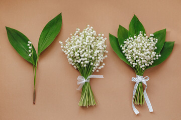 Set of lilies of the valley bouquets on beige background .