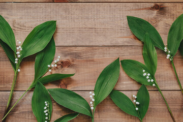 Lilies of the valley on natural wooden backgrond. Flower card.