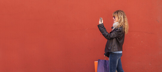 woman with shopping bags isolated on the wall in the street outdoors