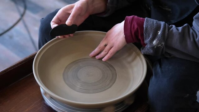 Pottery polishing process with 2 hands in the final step. Before entering the kiln. Slow motion video