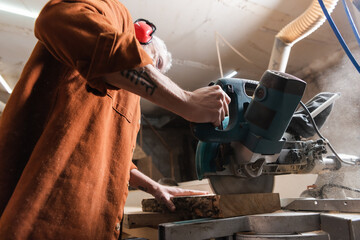 low angle view of woodworker cutting board with miter saw.