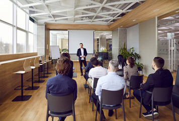 Businessman lead head business training or seminar for diverse businesspeople in boardroom. Male...