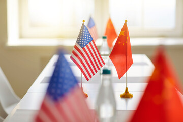 Negotiations between China and America. Close up of flags of China and United States on table at...