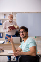 Old male teacher and young male student in the classroom