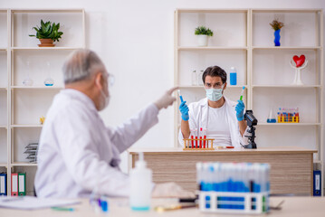 Two male chemist working at the lab