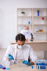 Two male chemist working at the lab