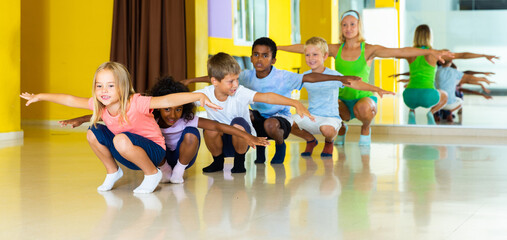 Cheerful little children studying modern style dance in class. High quality photo