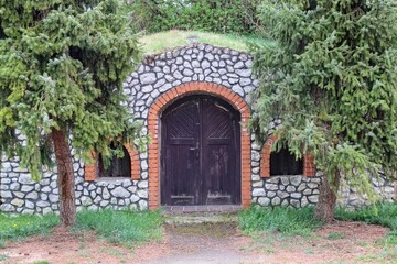 Fototapeta na wymiar A wooden entrance to the wine cellar built with stones at Nosislav, Czech republic
