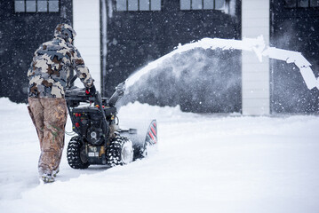 snow blower blowing snow in winter weather