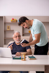 Grandfather and grandson at home with computer