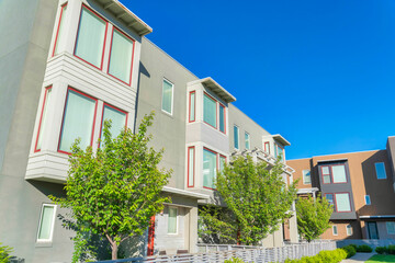 Multi-storey residential buildings with bay windows and trees at the front entrance