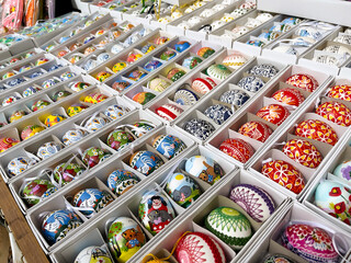 Multi-colored Easter eggs in boxes at the fair. Pattern festive