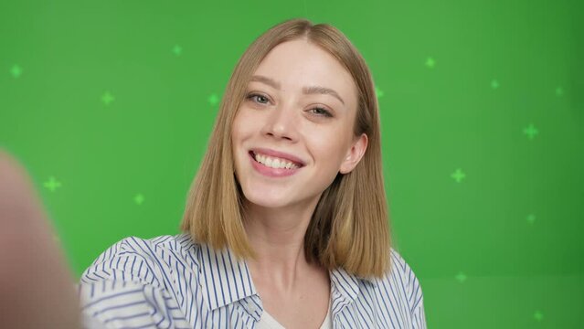 Young woman teenager speaking on video call, vlogger using smartphone talking at camera webcam online, selfie call, record lifestyle vlog, blogger online streaming on green screen . Chroma key