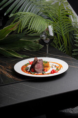 Cutaway steak with vegetables and sauce on a dish in a restaurant