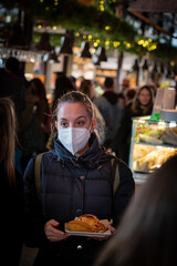 Young girl with a mask in the San Miguel market in Madrid, at lunchtime