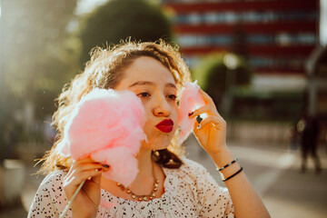 Obraz premium Mujer haciendo mueca mientras disfruta de su dulce. Algodón de Azúcar.