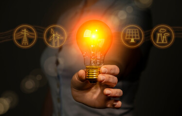 Hand holding light bulb with electricity extraction icons, electricity energy sources concept, power industry