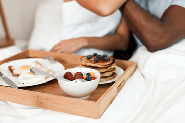 Obraz na płótnie Canvas Breakfast in bed is served. Shot of an unrecognizable couple enjoying breakfast in bed together at home during the day.