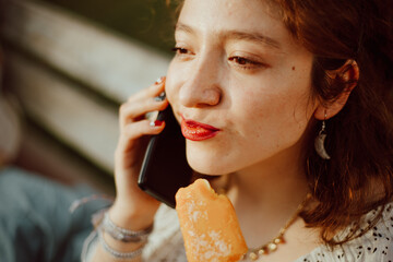 Retrato de mujer hablando por teléfono y comiendo un helado. Concepto de comunicación y turismo.