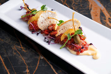 Snack on a white dish for a buffet table on a black marble table