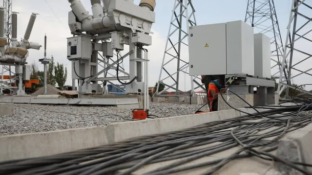 High-voltage cables laid in concrete duct at construction site of new power station. Installation of electrical connection on cloudy day
