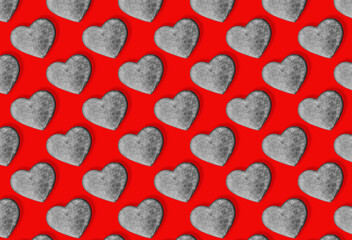 Seamless pattern with stone hearts on red.