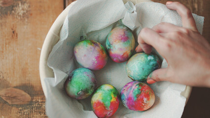 Easter Eggs decoration, hands showing decorations on Easter eggs placed in basket on wooden table 03