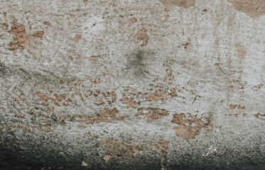 A weathered wall background with cracks in shades of black, beige and red. An old plaster wall with grunge texture.
