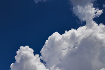 Naklejka na ściany i meble white cumulus cloud, looking like a cotton flake, floating under a blue sky.