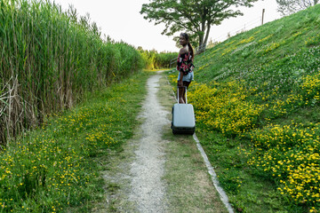 African American young woman with suitcase walking in outdoors,