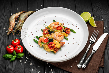 Omelet with shrimp, caviar and grilled tomatoes on a bed of green beans and bacon