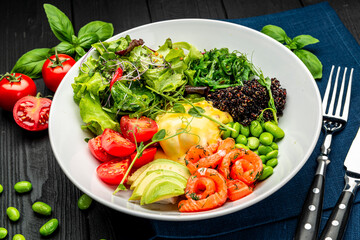 Healthy light breakfast with poached egg, salmon, avocado, tomato, lettuce and chia seeds