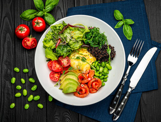 Healthy light breakfast with poached egg, salmon, avocado, tomato, lettuce and chia seeds