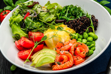 Healthy light breakfast with poached egg, salmon, avocado, tomato, lettuce and chia seeds