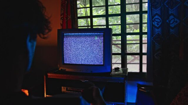 Man with remote control changes channel on tv with no signal