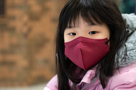 Coronavirus Covid-19, portrait of little asian kid girl wearing red color face mask