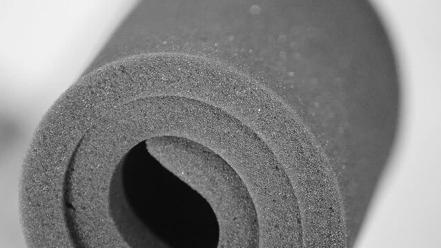 a roll of gray foam material on a blurred background