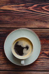 Mug of hot coffee on a wooden board